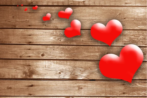 Червоні серця на дерев'яній текстурі — стокове фото