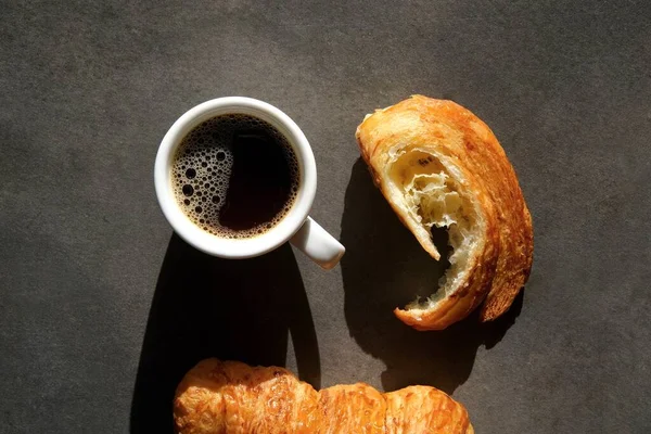 Witte Koffiebeker Kleurrijke Croissants Een Donkere Achtergrond Uitzicht Vanaf Bovenkant — Stockfoto