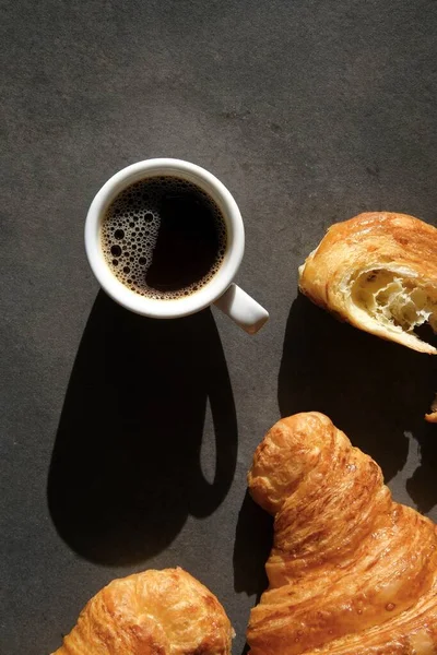 Vit Kaffekopp Och Färgglada Croissanter Mörk Bakgrund Utsikt Uppifrån — Stockfoto