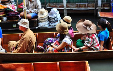 5 Şubat 2012, Tayland, yüzen pazar: Bir grup Asyalı turist bir bota binip hatıra fotoğrafı çekiyorlar.
