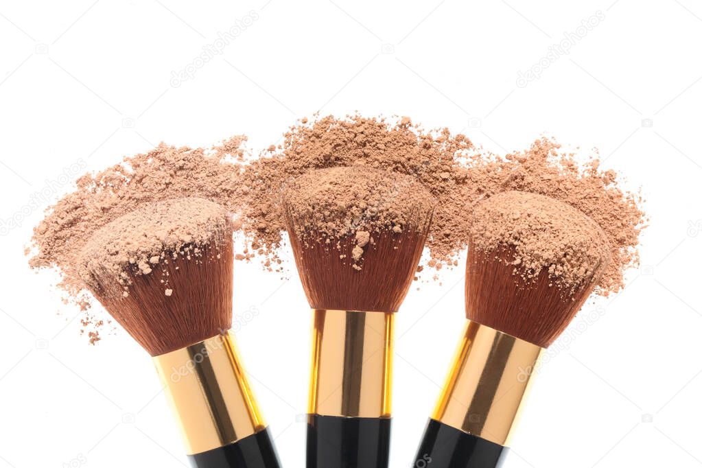 three make up brushes and brown face powder isolated on white background with clipping path and copy space for  your text