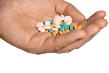 Vitamin hapları beyaz arka planda, avucunun içinde duruyor.