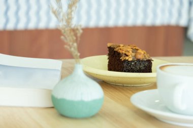 Kahve dükkanında kapuçino ile servis edilen şekerlemeli kek..