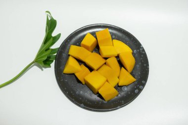 Siyah seramik tabakta olgun mangolar..