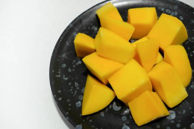 Siyah seramik tabakta olgun mangolar..