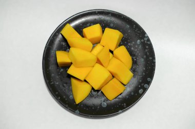 Siyah seramik tabakta olgun mangolar..