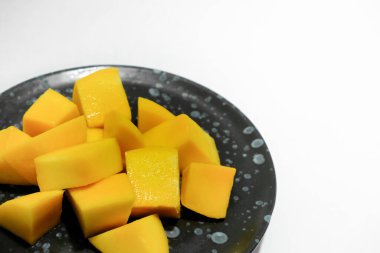 Siyah seramik tabakta olgun mangolar..