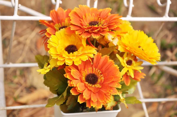 Orange and yellow plastic flowers — Stock Photo, Image