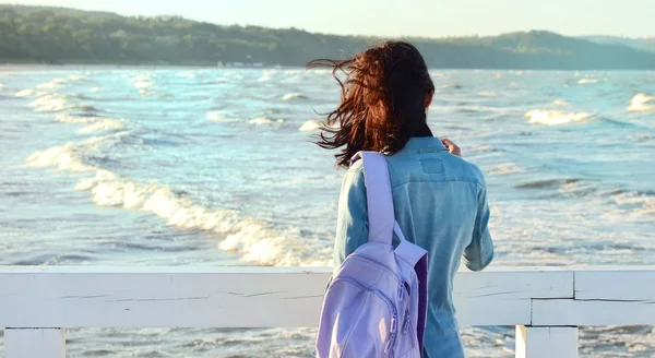 Vrouw met jeans overhemd jurk op een tropisch strand met tas — Stockfoto