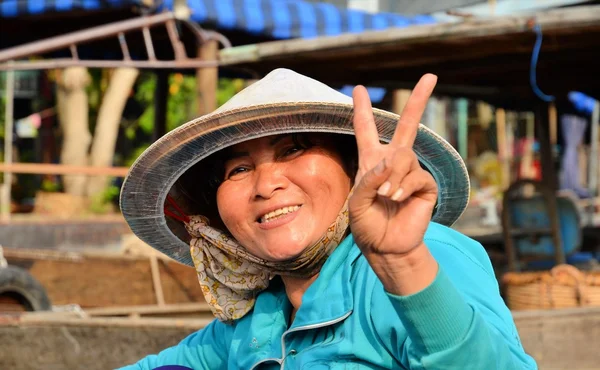 CAN THO - VIETNAM - MARZO 5 2015 mujer de azul en sombrero mostrando señal de victoria —  Fotos de Stock