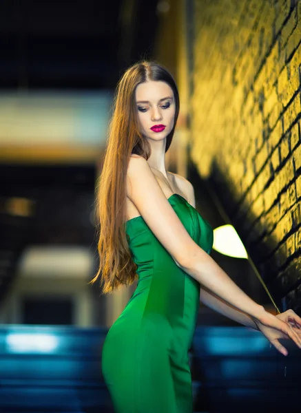 Женщина в зеленом платье спускается по лестнице — стоковое фото