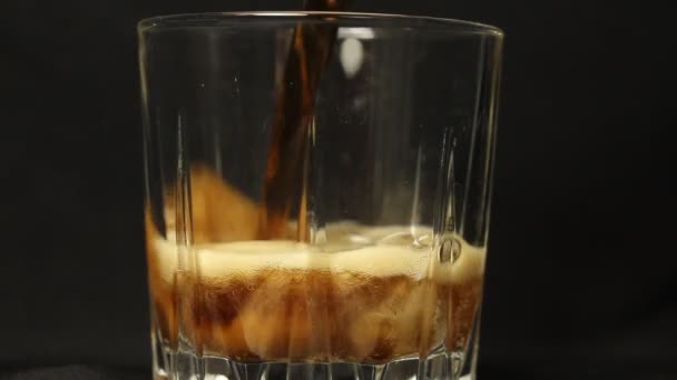 将碳酸可乐软饮料倒入装有冰块的杯子烧杯的过程 — 图库视频影像