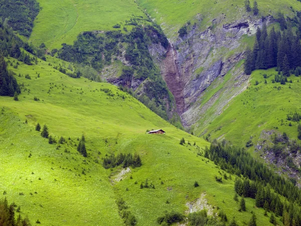 Wooden cottage in steep mountain landscape — Stock Photo, Image