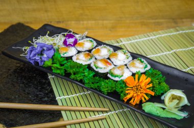 Mükemmel suşi, geleneksel Japon mutfağı. Süslü tabakta nefis hossomaki.