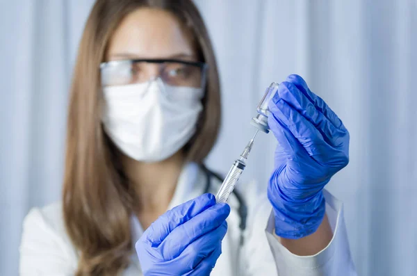 vaccine in researcher hands, female doctor holds syringe and bottle with vaccine for coronavirus cure. Concept of corona virus treatment, injection, shot and clinical trial during pandemic.