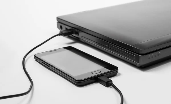 Smartphone charging power from a laptop — Stock Photo, Image