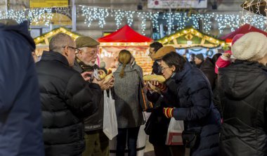 Bükreş'te Noel pazarında sosis yeme insanlar