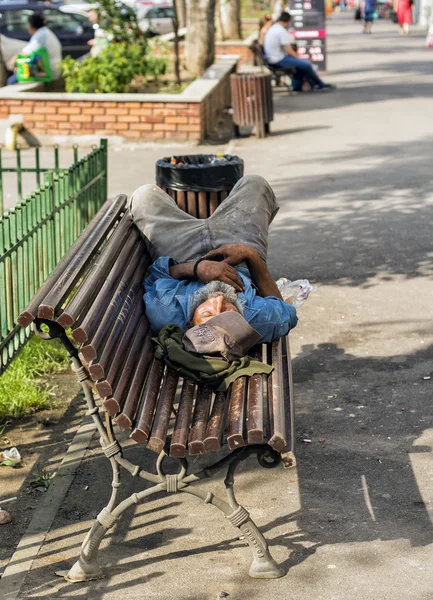 Obdachloser schläft bei Tageslicht auf Bank — Stockfoto