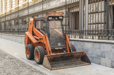 Municipali tarafından temizlik için kullanılan küçük turuncu buldozer makine