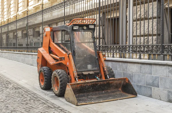 Pequeña maquinaria bulldozer naranja utilizada para la limpieza por municipali — Foto de Stock