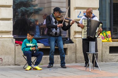 Şehir merkezinde çeşitli müzik aletleri oynayan erkek grup