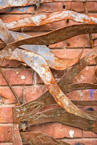 Twisted iron plates on brick wall — Stock Photo, Image