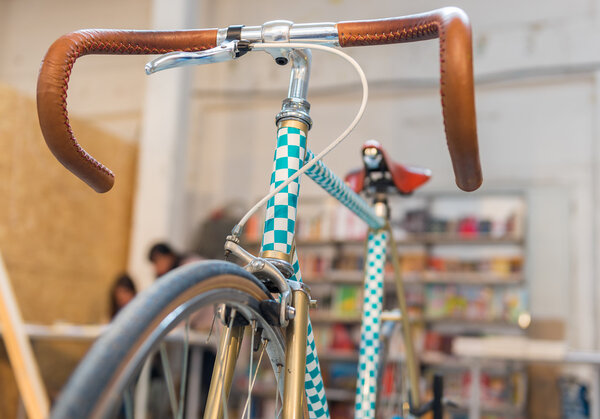 Ретро велосипед с кожаным рулем и шашки краски
