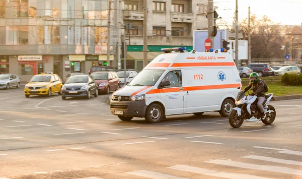 白色救护车汽车行驶得很快在布加勒斯特的街道上 免版税图库照片