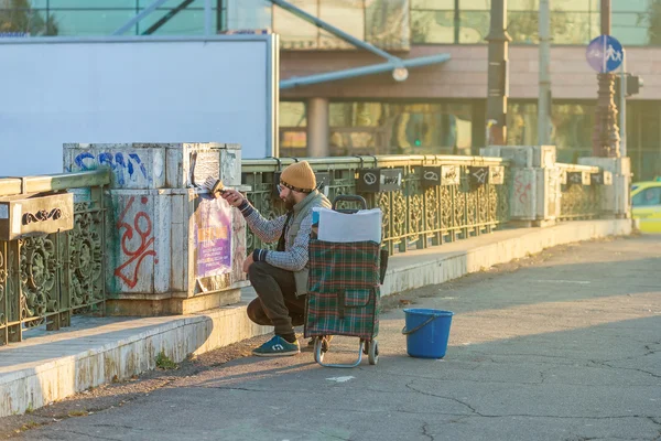 Hombre pegando un cartel en un puente —  Fotos de Stock