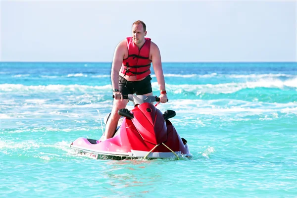 Young guy cruising on a jet ski on the caribbean sea — Stock Photo, Image