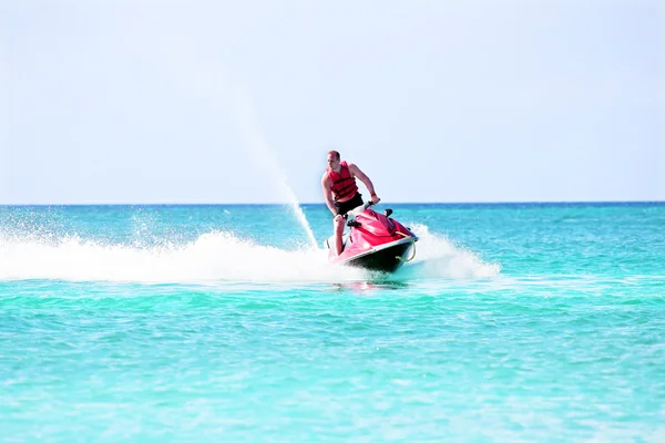 Young guy cruising on a jet ski on the caribbean sea — Stock Photo, Image