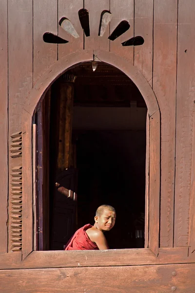 NLE,MYANMAR-November 24 : Young novice monk at window wooden Chu — Stock Photo, Image