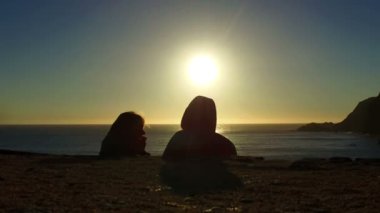 Gün batımında sahilde iki insanlar