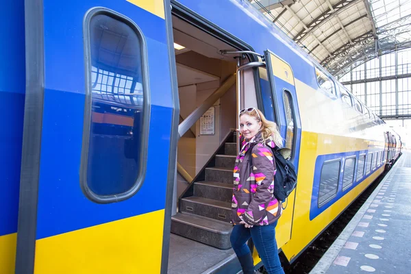 Giovane donna che prende il treno nella stazione centrale di Amsterdam in t — Foto Stock