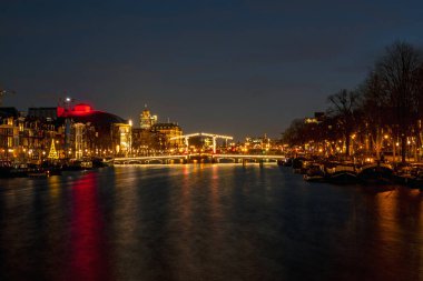 Amsterdam 'da küçük bir köprü. Hollanda' da gün batımında Amstel 'de.
