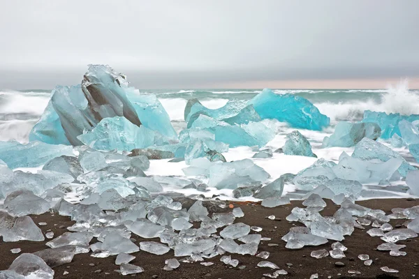 Ijs stenen op een zwarte zand strand in IJsland — Stockfoto