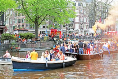 Amsterdam kanallarında tekne ve insanlar dolu