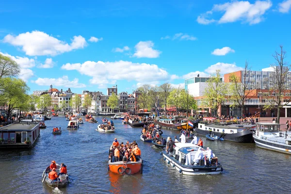 ABRIL 27: Canais de Amsterdã cheios de barcos e pessoas em Orange du — Fotografia de Stock