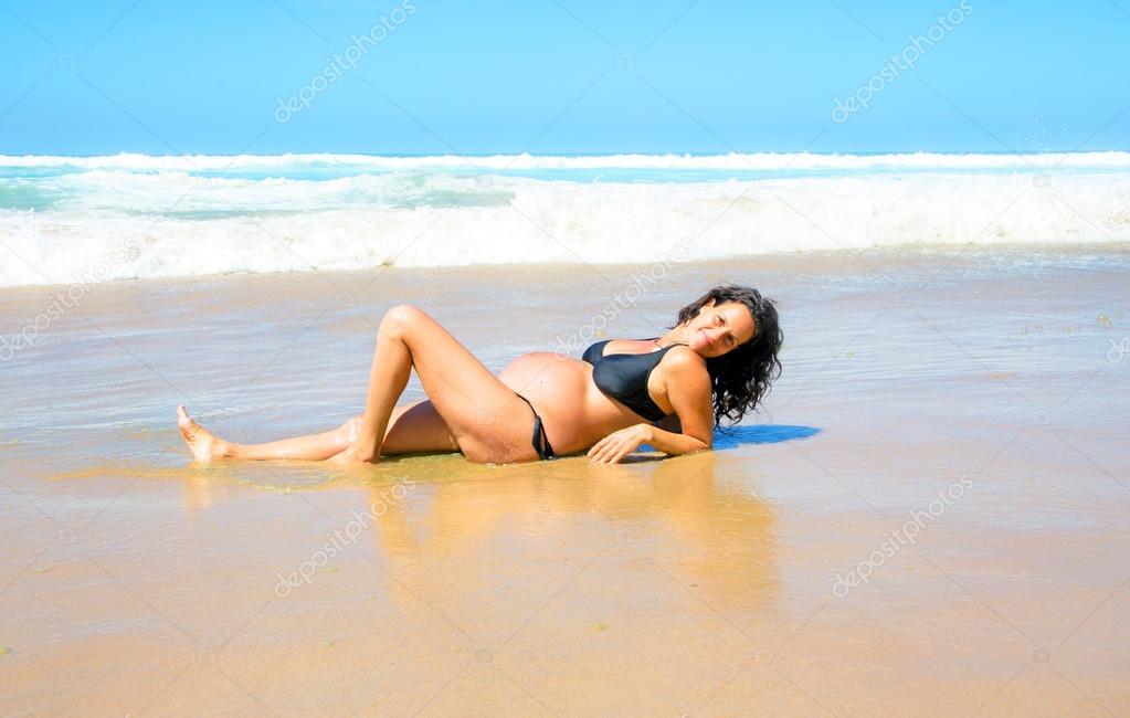 Pregnant woman on the beach at the atlantic ocean