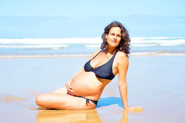 Gravid kvinna på stranden vid Atlanten — Stockfoto