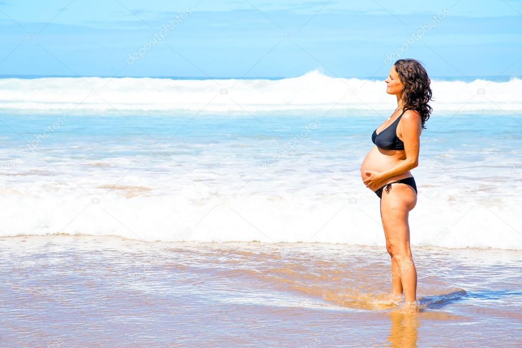 Beautiful pregnant woman at the beach