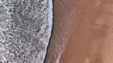 Sahildeki okyanus dalgalarından havadan çekilen görüntü. Yüksek kalite 4k görüntü