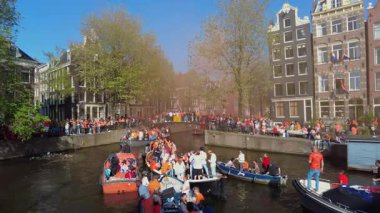 AMSTERDAM, NETHERLANDS - 27 Nisan 2025: Hollanda kanallarında yerel halk Kingsday 'i kutluyor. Yüksek kalite 4k görüntü