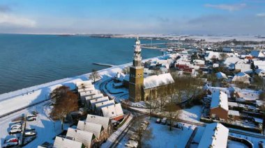 Hollanda 'nın IJsselmeer kenti yakınlarındaki tarihi Hindeloopen kasabası kış boyunca karla kaplıydı. Kilise etrafındaki hava hareketleri geleneksel mimari, miras ve sakin bir kış atmosferini vurguluyor.