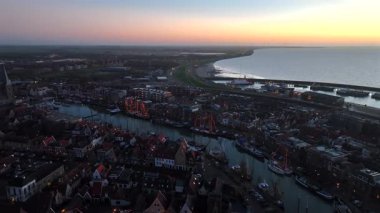 Hollanda 'nın tarihi kenti Harlingen' de günbatımında aydınlatılmış eski moda teknelerle yılbaşı zamanından bir video.
