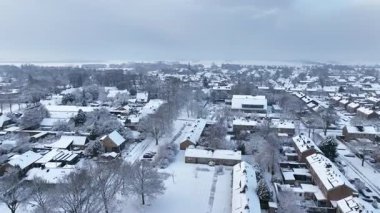 Kışın karla kaplı tarihi bir Avrupa köyü, çatıları ve sokakları sakin ve atmosferik bir kış manzarası yaratıyor.