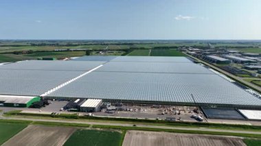 Bahçecilik için kullanılan büyük bir sera kompleksi, kontrollü koşullar altında geniş tarım altyapısını ve ekimini gösteriyor.