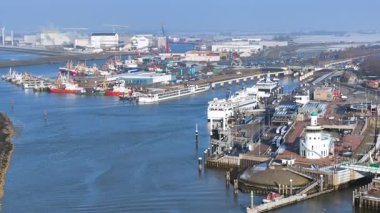 Bir Avrupa limanından ön planda deniz feneri ve feribotları ve bir tarafında açık deniz bulunan bir balıkçı limanını görürüz.