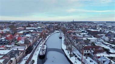 Soğuk mevsimsel koşullar altında geleneksel binaları, caddeleri ve rıhtımı olan karlı tarihi bir Avrupa şehrine kış manzarası