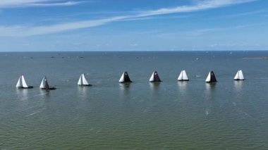 Avrupa 'daki IJsselmeer' de yapılan bir yarış sırasında geleneksel yelkenli teknelerin manzarası, tarihi gemileri, açık deniz ve deniz kültürünü gösteriyor.